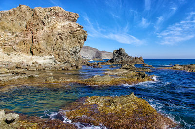 Scenic view of rocks in sea against sky