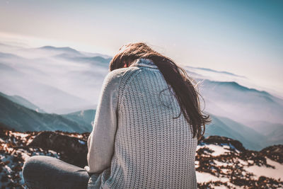 Rear view of woman on beach against sky