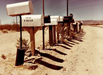 Sign board on field against sky