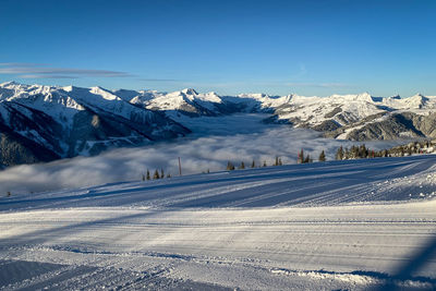 Scenic view of snowcapped mountains against blue sky