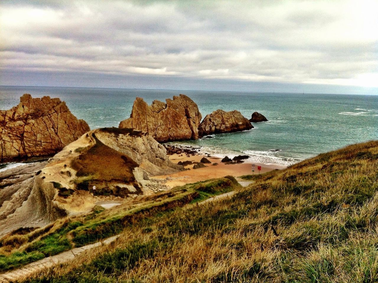 sea, sky, tranquil scene, tranquility, horizon over water, scenics, beauty in nature, water, cloud - sky, rock formation, nature, rock - object, cloudy, cloud, cliff, idyllic, grass, rock, landscape, non-urban scene