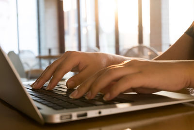 Midsection of man using laptop on table