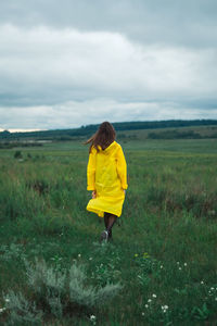 Rear view of woman standing on field