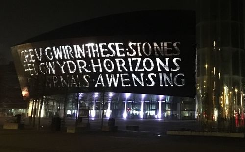 Close-up of illuminated information sign at night