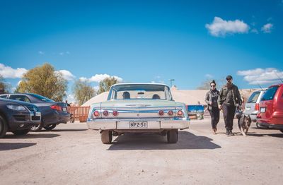 People on road against blue sky
