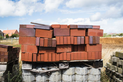 Stack of stone wall on field against sky