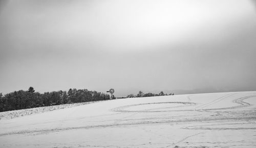 Scenic view of snow covered field against sky