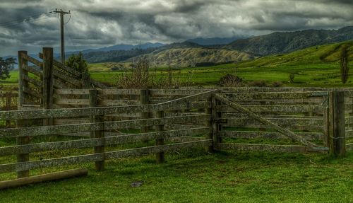 Scenic view of grassy field against cloudy sky