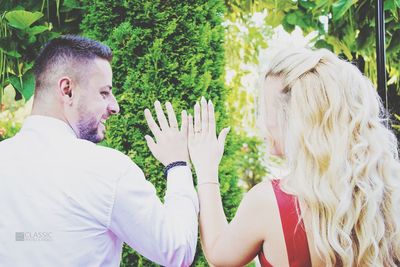 Close-up of couple kissing against trees