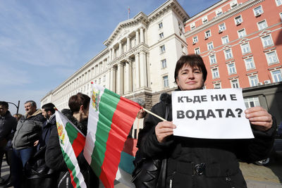 People on street against buildings in city