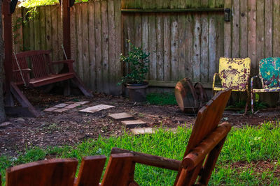 Abandoned chair against plants in yard