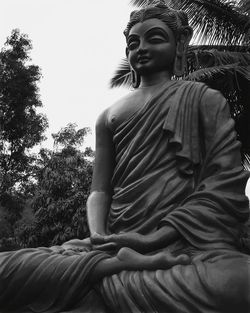 Low angle view of woman looking away against sky