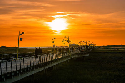 Pier over sea against sky during sunset