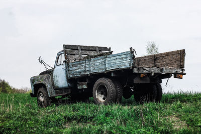 Abandoned truck on field against clear sky