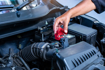 Cropped hands of man repairing car engine