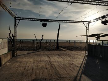 Empty porch by sea against sky during sunset