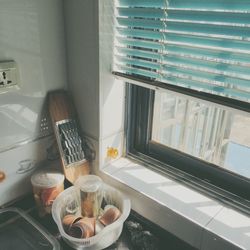 High angle view of containers by window in kitchen at home