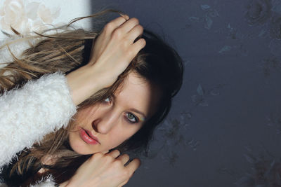 Close-up portrait of young woman against wall