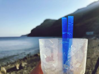 Close-up of glass of water on beach