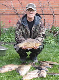 Full length of man holding fish on field