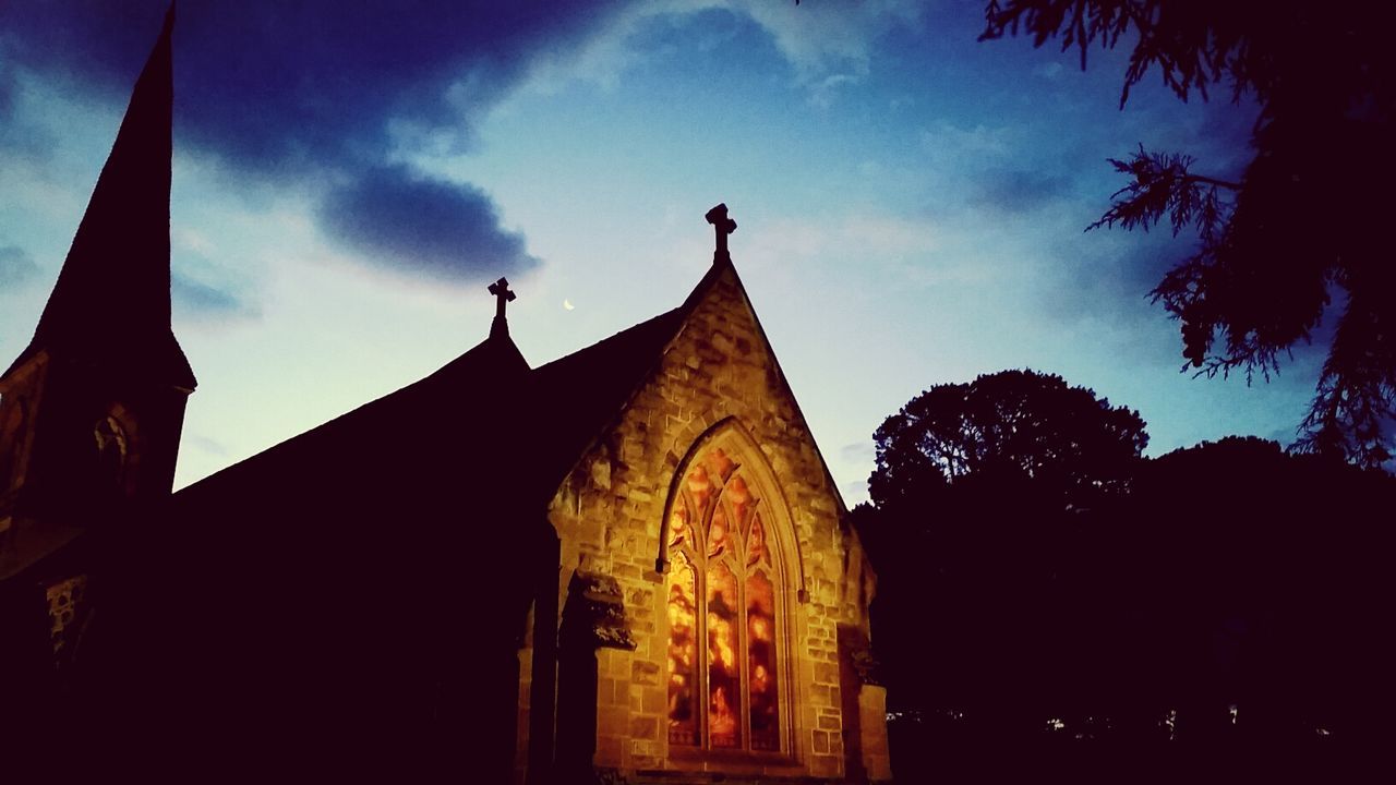 low angle view, religion, place of worship, sky, spirituality, architecture, built structure, building exterior, silhouette, tree, temple - building, church, art and craft, dusk, history, cloud - sky, outdoors