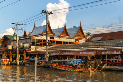 Sailboats in river against buildings