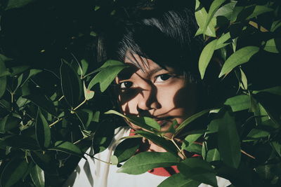 Portrait of girl standing by plants