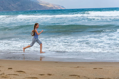 Full length of boy on beach against sky