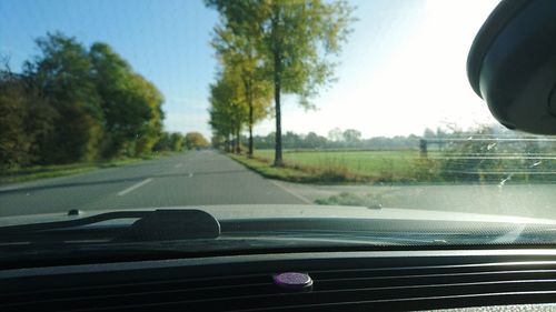 Road amidst trees against clear sky