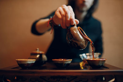 Cropped hand of man preparing food on table