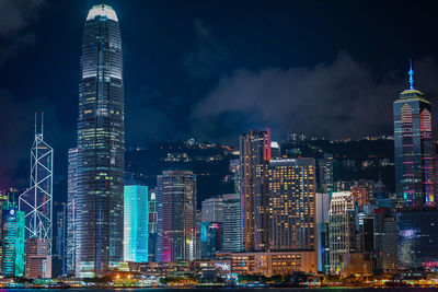 Illuminated buildings in city against sky at night