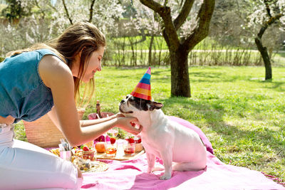 Side view of woman with dog on field