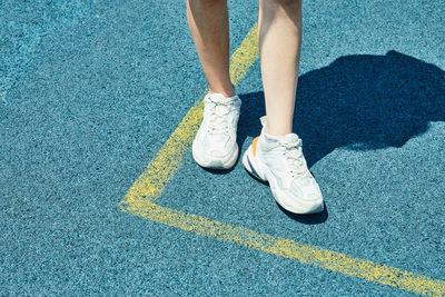 Low section of woman standing on road