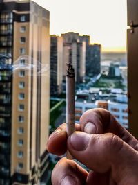 Close-up of hand holding cigarette