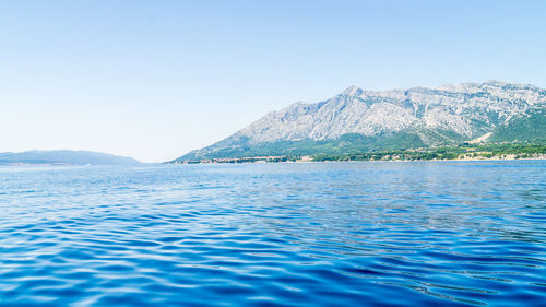 Scenic view of lake against clear blue sky