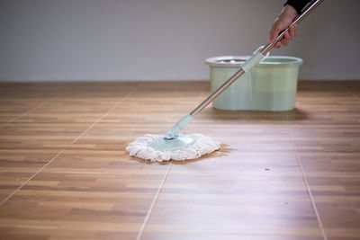 Woman holding umbrella on hardwood floor at home