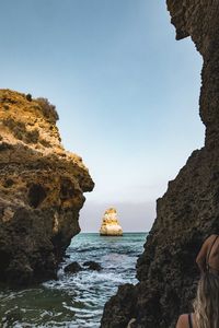 Rock formations on beach against clear sky