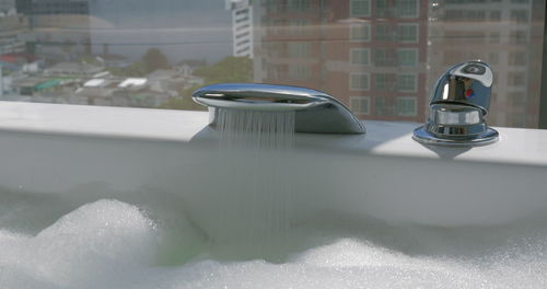 Close-up of water flowing from faucet at home