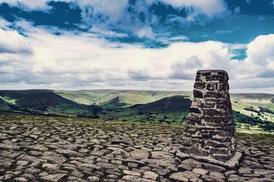 Built structure by landscape against sky