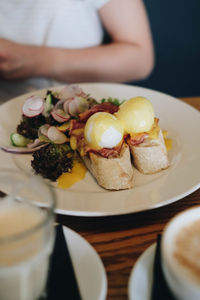 Close-up of hand holding food in plate