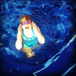 High angle view portrait of girl swimming in pool