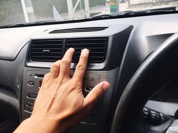 Cropped image of hand on car