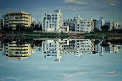 Reflection of buildings in lake against sky