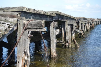 Wooden pier over sea against sky