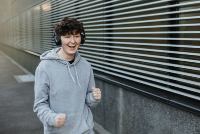 Portrait of young man standing against wall