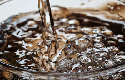 Close-up pouring water into glass