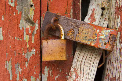 Close-up of rusty padlock on wooden door