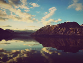 Scenic view of lake by mountains against sky