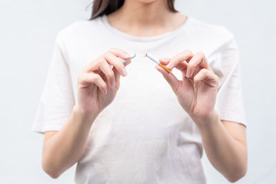 Midsection of woman standing against white background