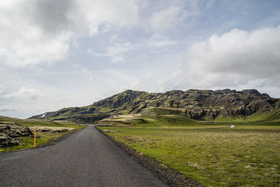 Road amidst land against sky